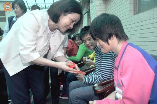 行政院院長吳敦義夫人蔡令怡，昨日在縣長李沃士等人陪同下，前往晨光關懷園生，致贈「台灣加油」福袋。（陳麗妤攝）