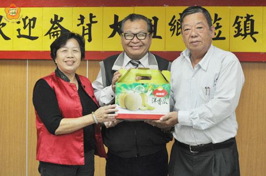   雲林縣崙背鄉鄉長李永茂（中）率隊到金沙姊妹鎮作客，帶哈密瓜相贈，行銷崙背特色，金沙也回贈名產致意。（陳麗妤攝）