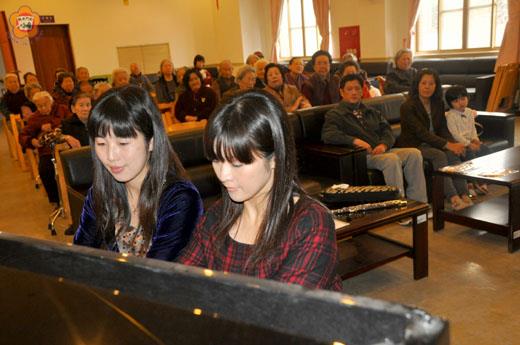   寒冬送暖，徐元婕、徐元妤兩姊妹花為大同之家院民帶來一場懷舊歌曲的音樂會：兩姊妹四手聯彈台灣歌謠「丟丟銅仔」，博得掌聲。（許加泰攝）