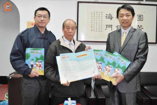 　海巡署金門機動查緝隊首度印製了「王伯伯說故事-浯洲海巡精彩100」繪本童書，將分贈地區各國小，分隊長謝忠諭（右一）送往縣府，由教育局長李再杭（中）代表接受。（莊煥寧攝）