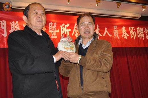 縣府昨日辦理縣府暨所屬機關編制內退休員工春節聯誼餐會:李縣長致贈紀念酒一盒,由退休協會理事長張光海代表接受。(李金鎗攝)