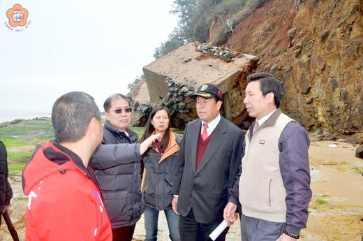   內政部國家公園計畫委員會專案小組現地勘查烈嶼青岐南山頭海岸侵蝕的情形：上、縣長李沃士（左二）看到昔日的軍事碉堡不堪海蝕而頹倒，該區域珍貴的玄武岩，面臨到受破壞的危機，和金管處有共同維護的共識。（許加泰攝）
