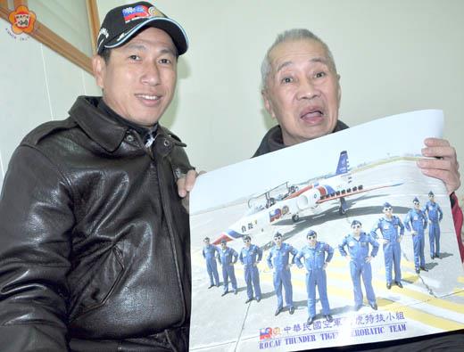   楊肅祺（左）將「中華民國空軍雷虎特技小組」的海報送給小學老師張水良（右）。海報中的左起第二人就是他。
（張建騰攝）