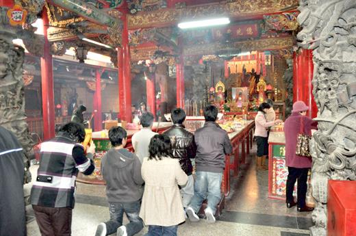   春節期間，闔家一起到寺廟燒香拜拜，祈求新的一年平安順遂。（莊煥寧攝）