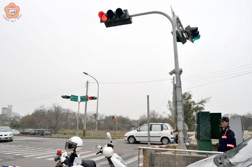 金城警分局派遣警力適時操控金城鎮環島西路一段與北堤路路口紅綠燈號，以維護行車安全與車流順暢。（莊煥寧攝）