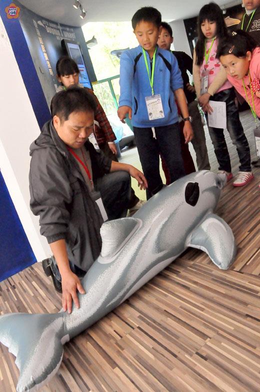   講師郭爵錕（前）正在解說鯨豚擱淺的處理方式。（張建騰攝） 
