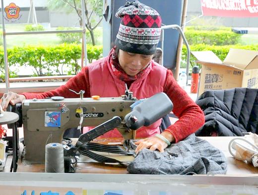 環保志工陳美雪，巧手將回收衣物變黃金，打造出獨一無二的環保包配合園遊會義賣。（陳麗妤攝）