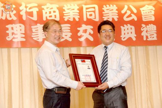  金門旅行商業同業公會新任理事長周子傑從縣長李沃士手中接下當選證書。（董森堡攝）